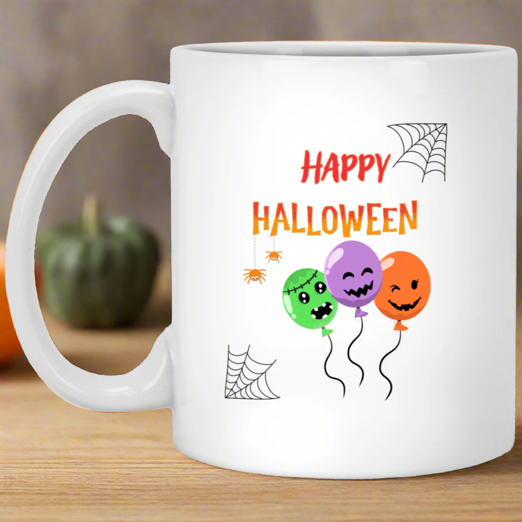 A white ceramic mug with a 'Happy Halloween' text and decorations featuring a spider, pumpkin, and balloon design.