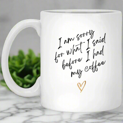 White mug with humorous text and a heart on a wooden surface