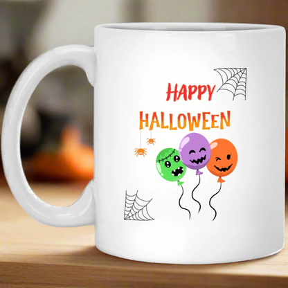 A white ceramic mug with a 'Happy Halloween' text and decorations featuring a spider, pumpkin, and balloon design.