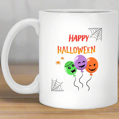 A white ceramic mug with a 'Happy Halloween' text and decorations featuring a spider, pumpkin, and balloon design.